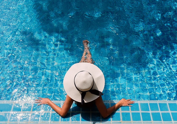 Woman lounging in a pool on an all inclusive vacation